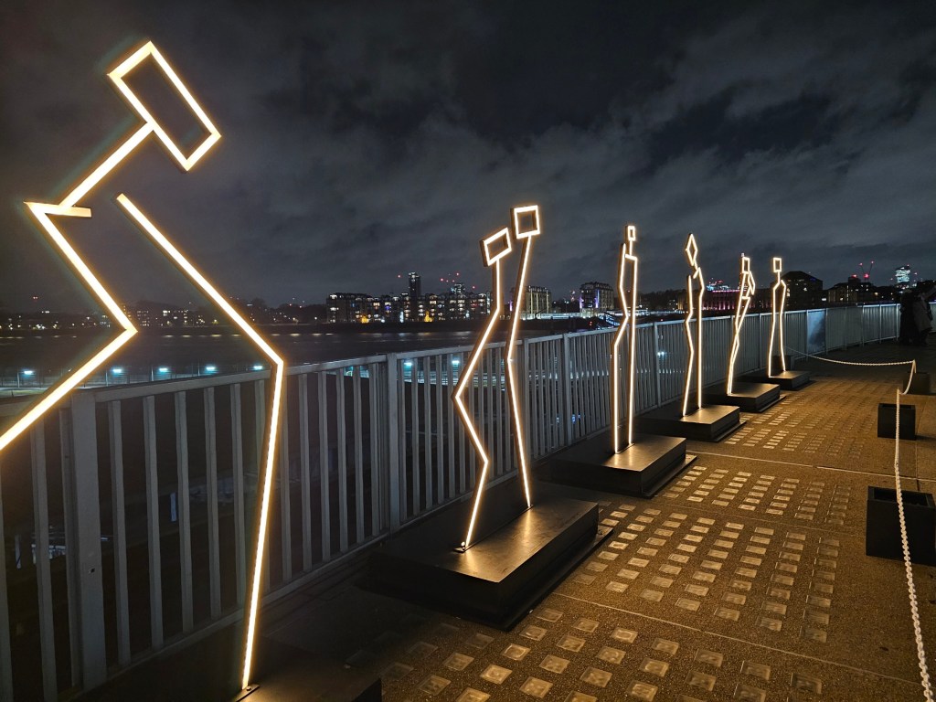 Six neon light sculptures resembling humanoid shapes