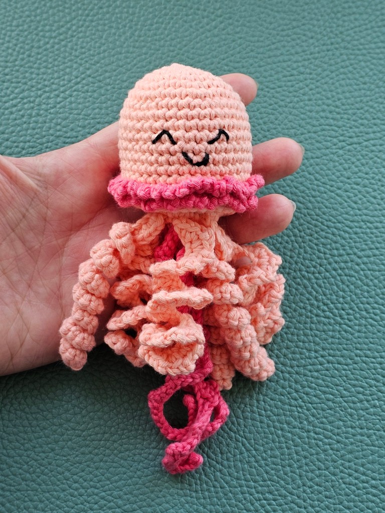 Completed crocheted jellyfish in peach and pink colour