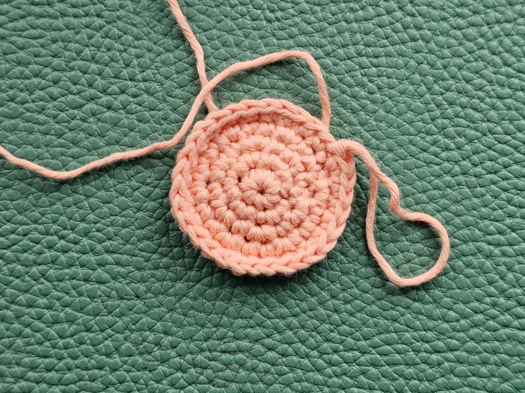 Crocheted peach coloured flat circle