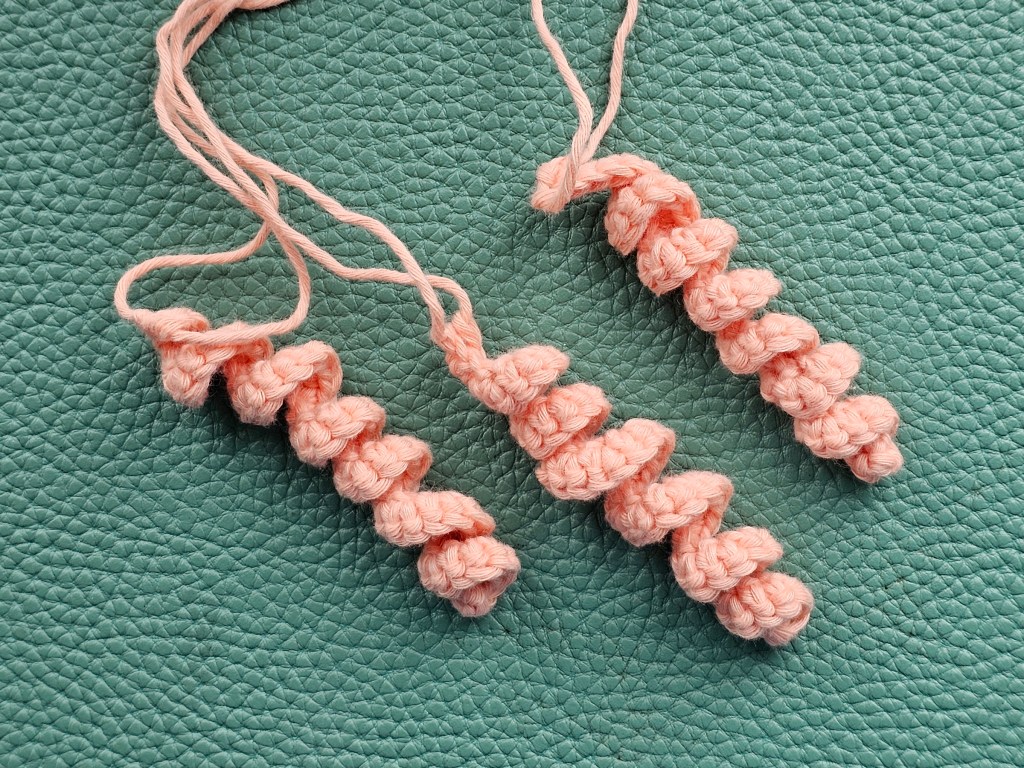 Three peach coloured spiral tentacles of a jellyfish