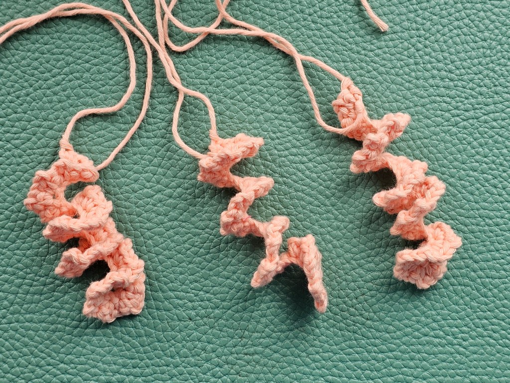Three peach coloured spiral tentacles of a jellyfish