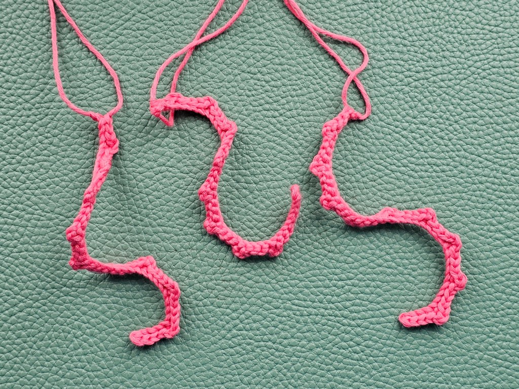 Three pink crocheted tentacles of a jellyfish