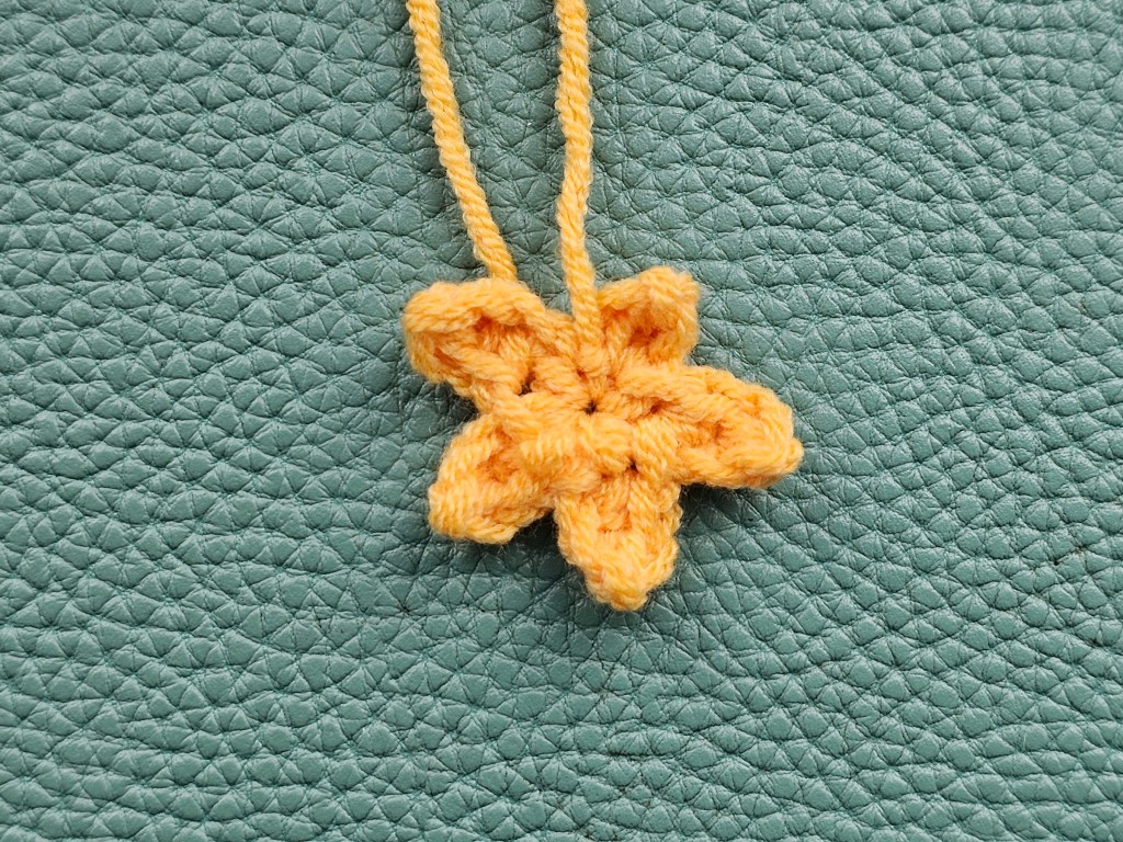 Crocheted star-like orange shape, to make the fringe of a chicken
