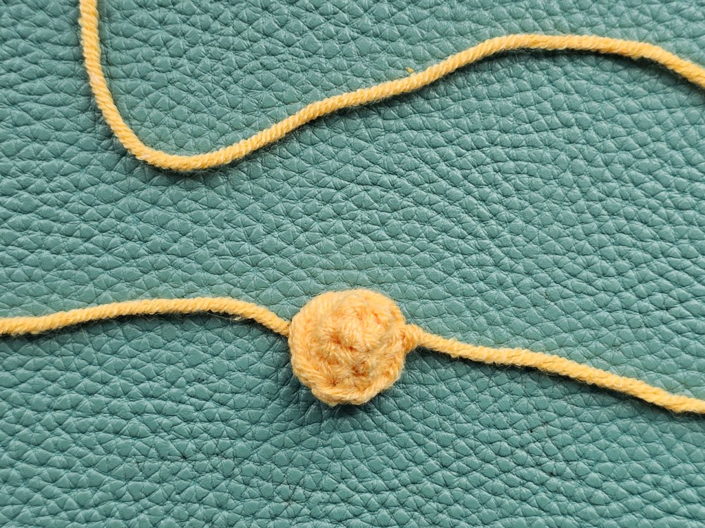 Tiny crocheted orange dome that will make a beak of a chicken