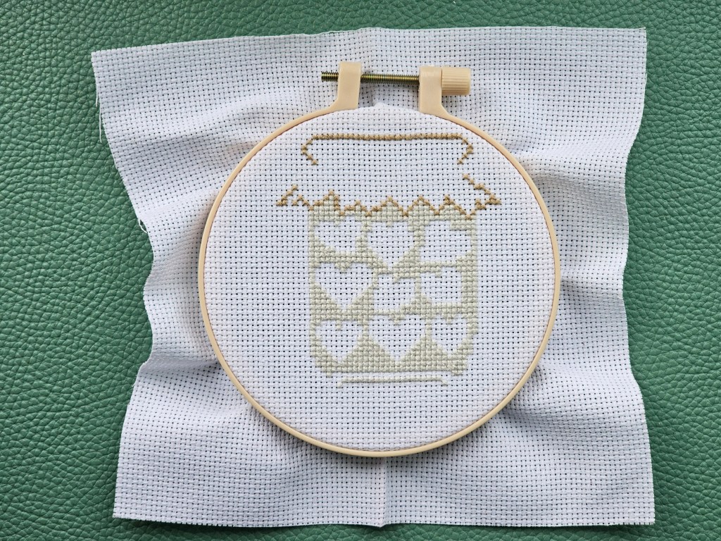 Partially completed cross stitch project featuring a jar of hearts.