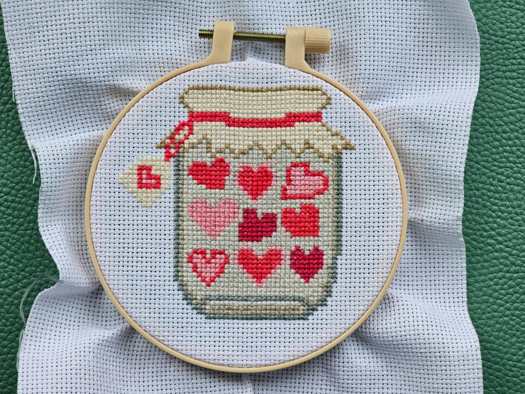Completed cross stitch project featuring a jar of hearts.
