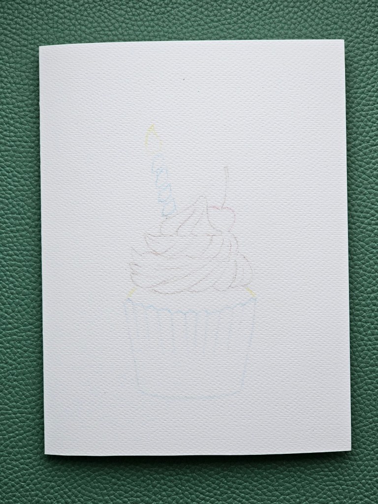Sketch of a handmade birthday card featuring a cupcake with a candle