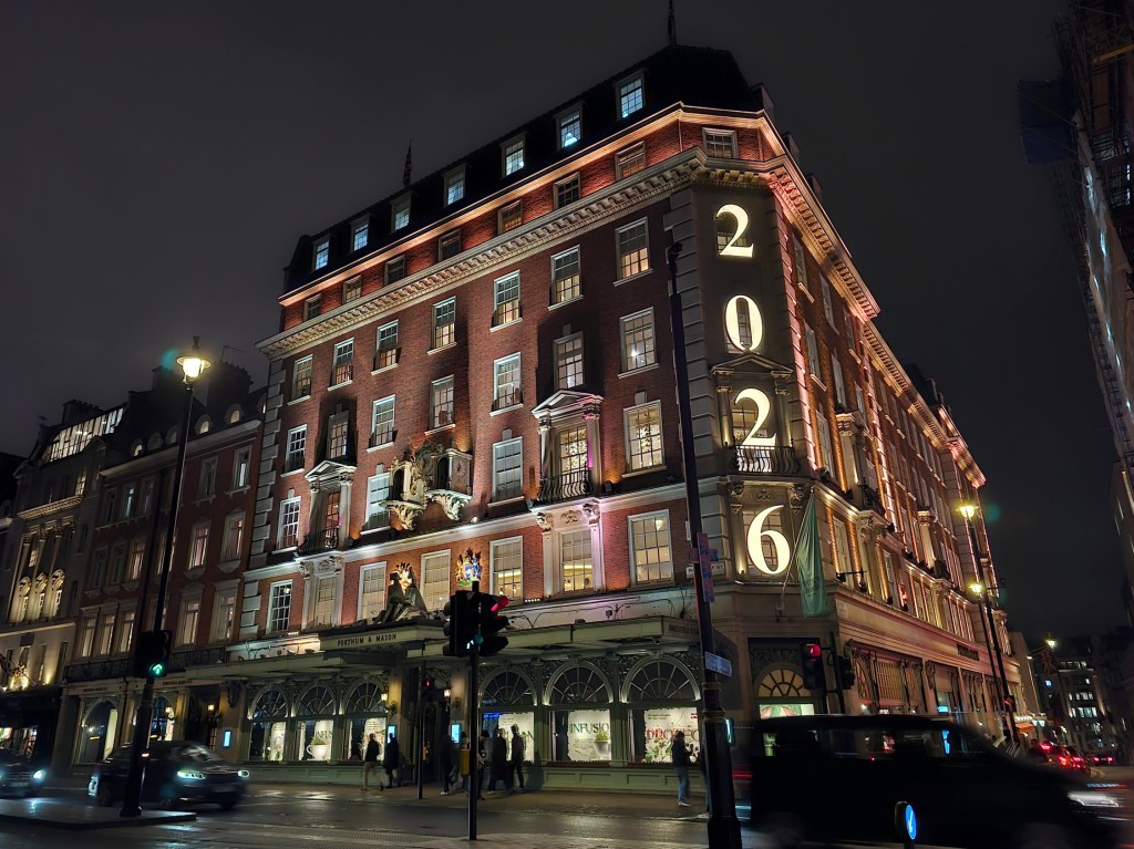 A neon sign spelling 2026 on the facade of Fortnum & Mason department store in London