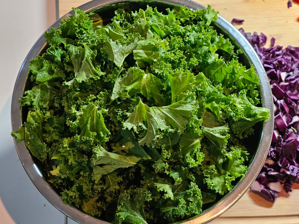 A metal bowl filled with pieces of kale