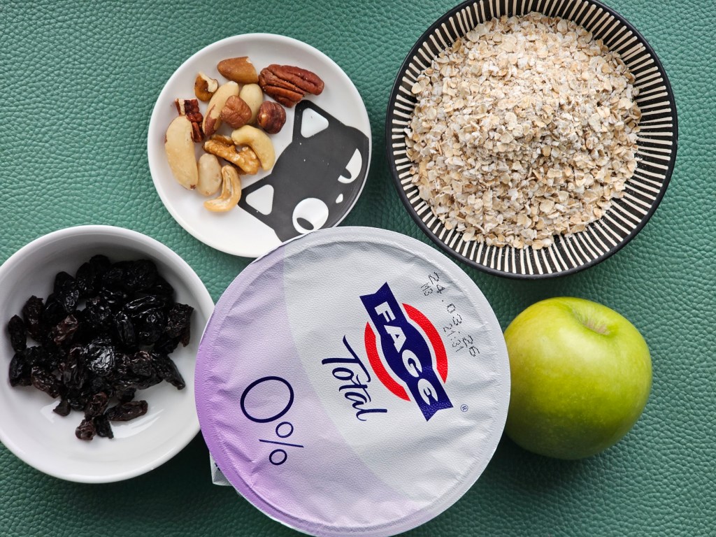 Ingredients for overnight Bircher oats: nuts, raisins, Granny Smith apple, yoghurt, oats
