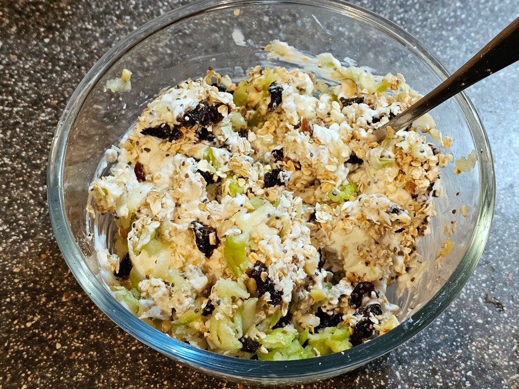 A bowl with mixed ingredients for overnight Bircher muesli