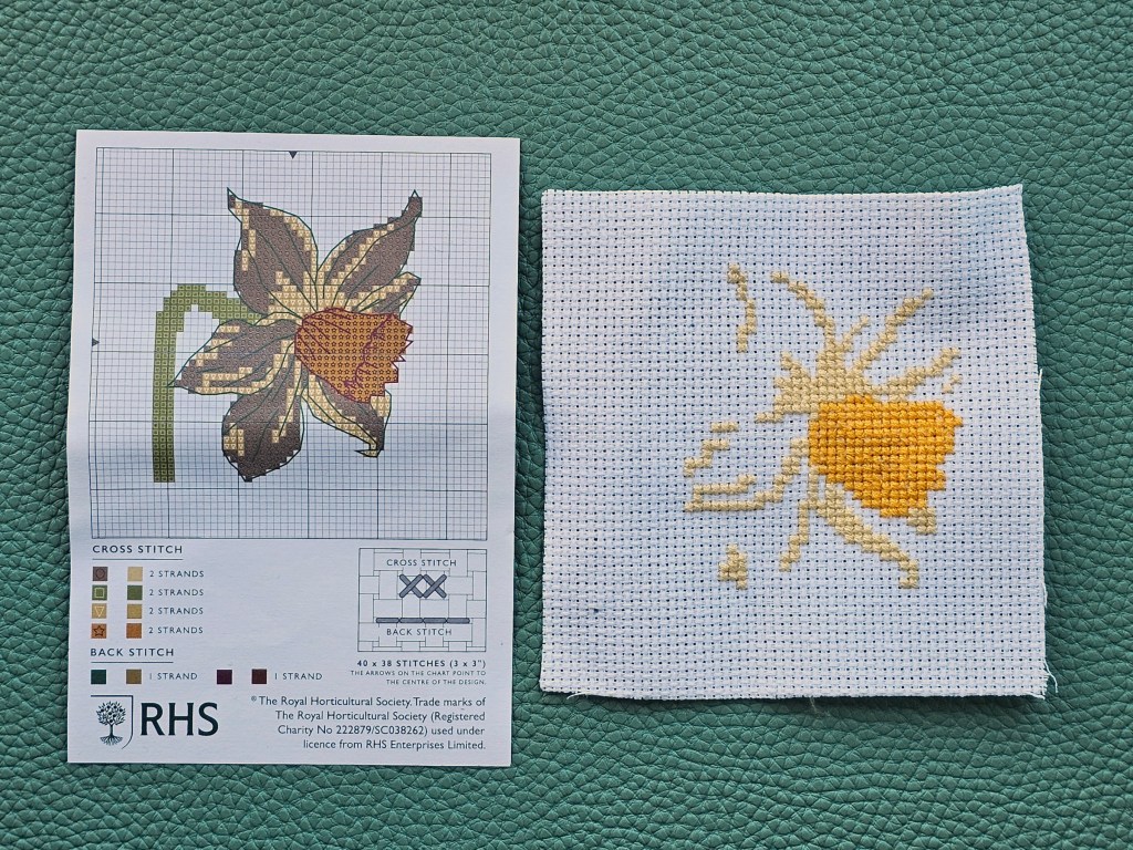 Partially completed small cross stitched daffodil from an assorted kit