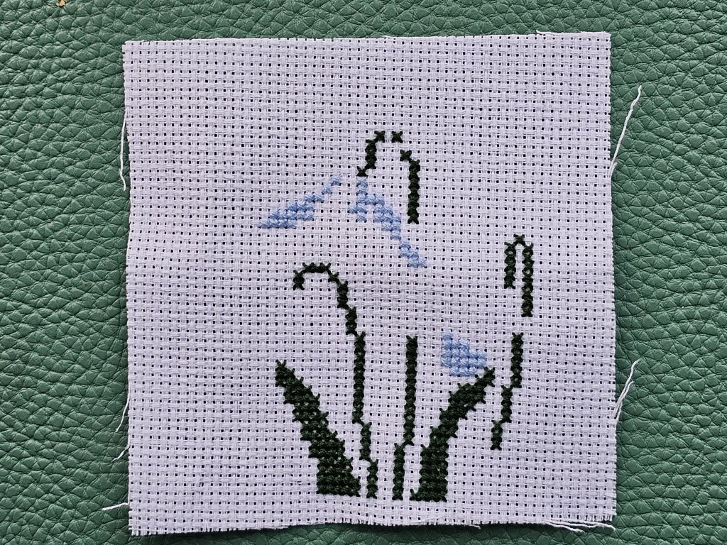 Partially completed cross stitch design that will eventually depict snowdrops