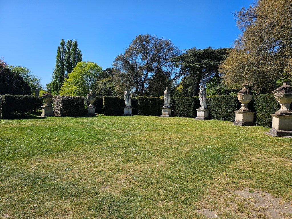 Roman Garden of Chiswick House, London. There are Roman style statues of people and vases.