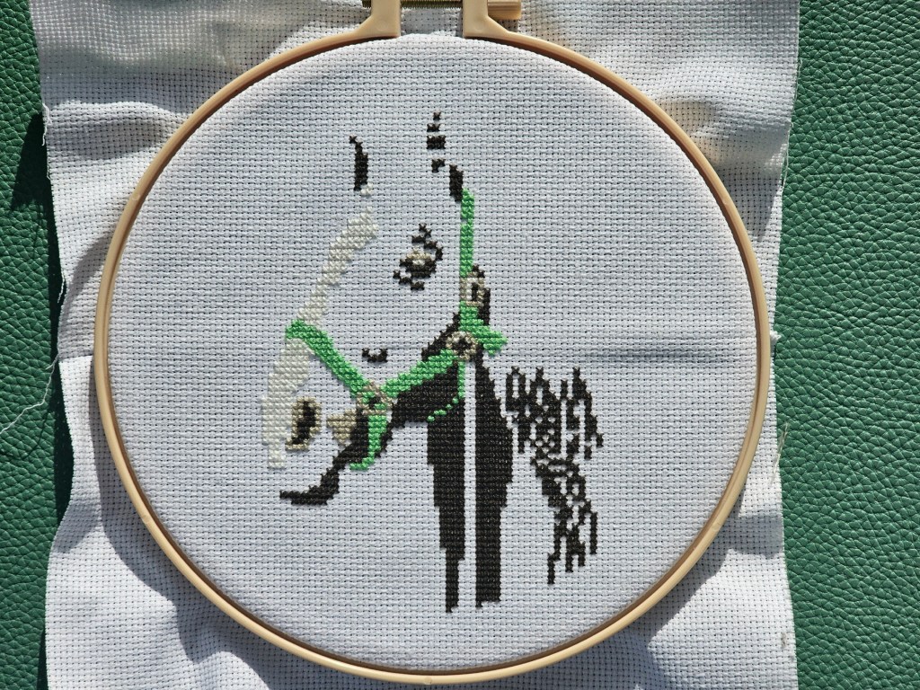 Partially completed cross stitch project featuring a horse. White, teal and grey elements are finished. Brown parts are left to sew.