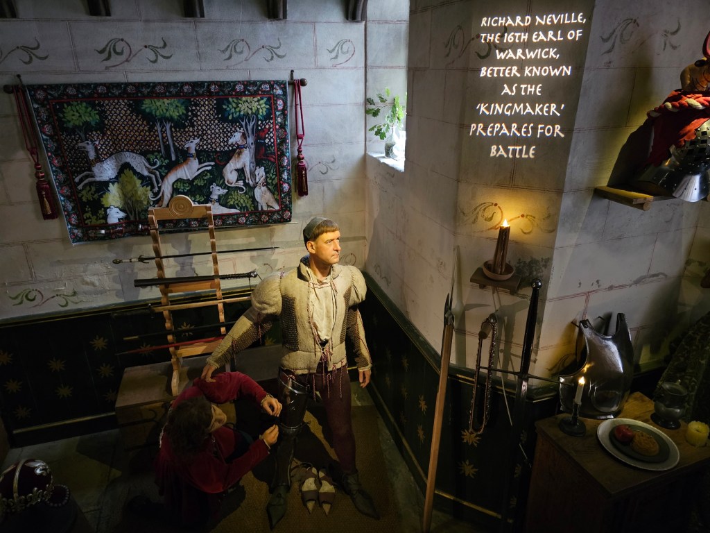 Kingmaker exhibition at Warwick Castle. It tells a story of Richard Neville. The room has a figure of the man, and a figure of his assistant adjusting his clothes