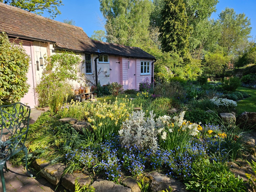 Mill Garden next to Warwick Castle. There's a small house, painted pink, and lots of colourful flowers