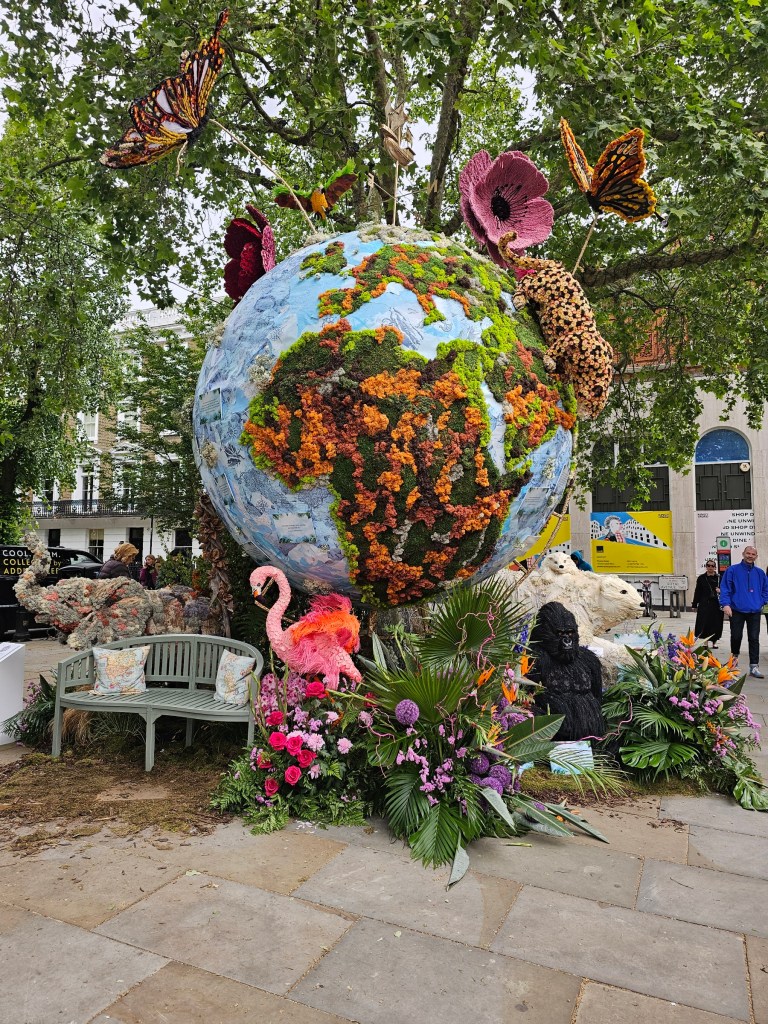 A huge floral display depicting a large globe surrounded my exotic animals, made out of flowers. Photo taken during Chelsea in Bloom 2026 event in London