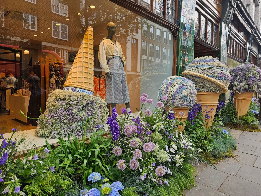 A floral display outside of a shop, featuring giant ice cream cones made out of flowers. Photo taken during Chelsea in Bloom 2026 event in London