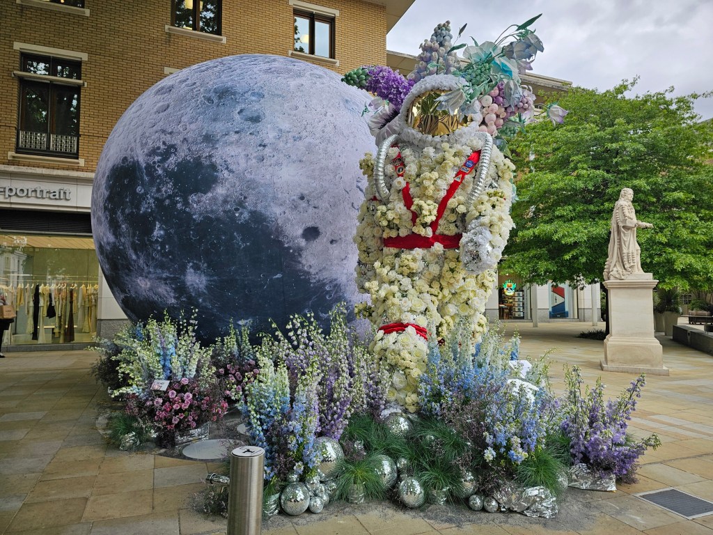 A huge floral display featuring a spaceman and a moon. Photo taken during Chelsea in Bloom 2026 event in London