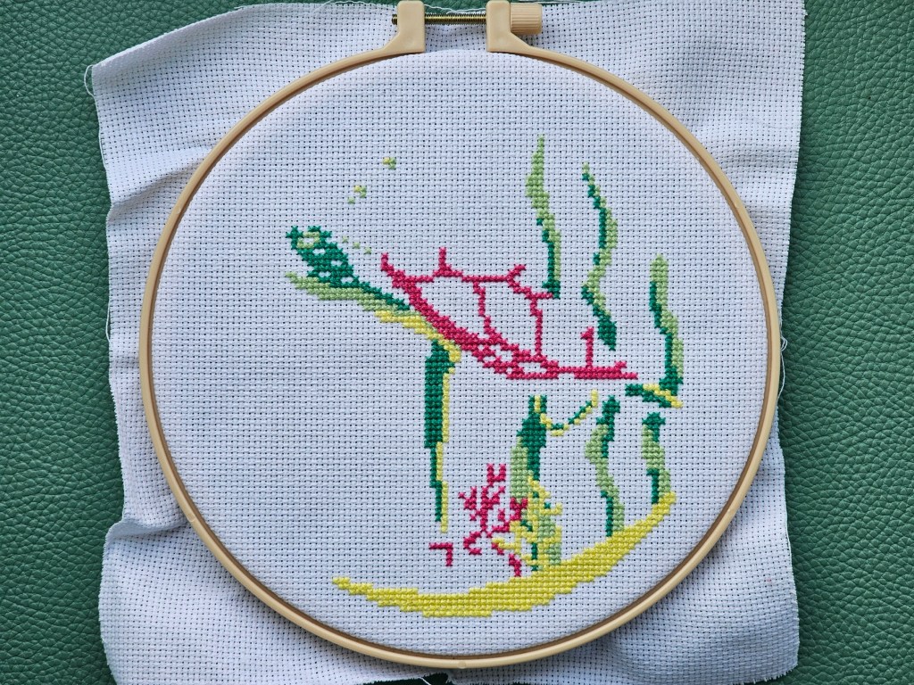 Partially completed cross stitch design featuring a turtle