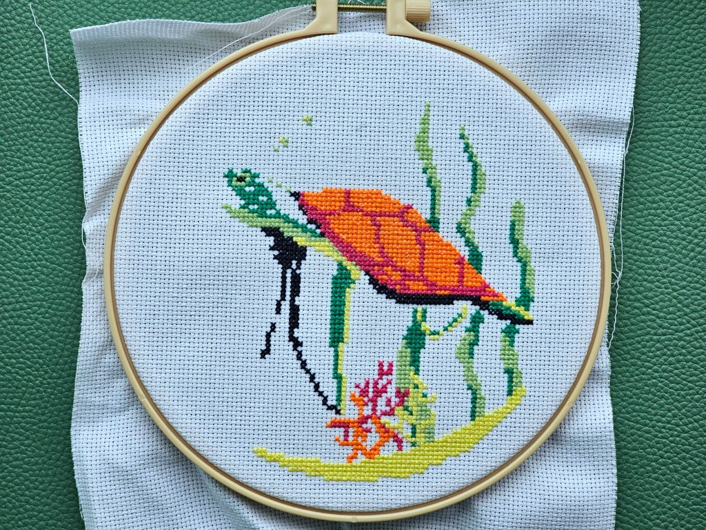 Nearly completed cross stitch design featuring a turtle