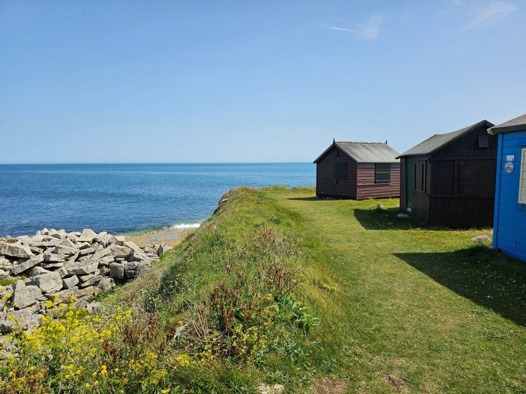 Colourful wooden huts near Portland Bill lighthouse, Isle of Portland, UK