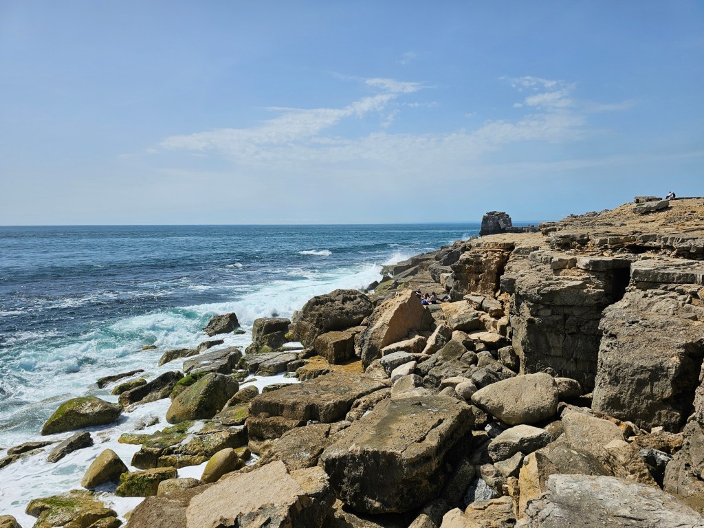 Rocky beach at Portland Bill, Dorset, UK. The waves are crashing at large rocks.