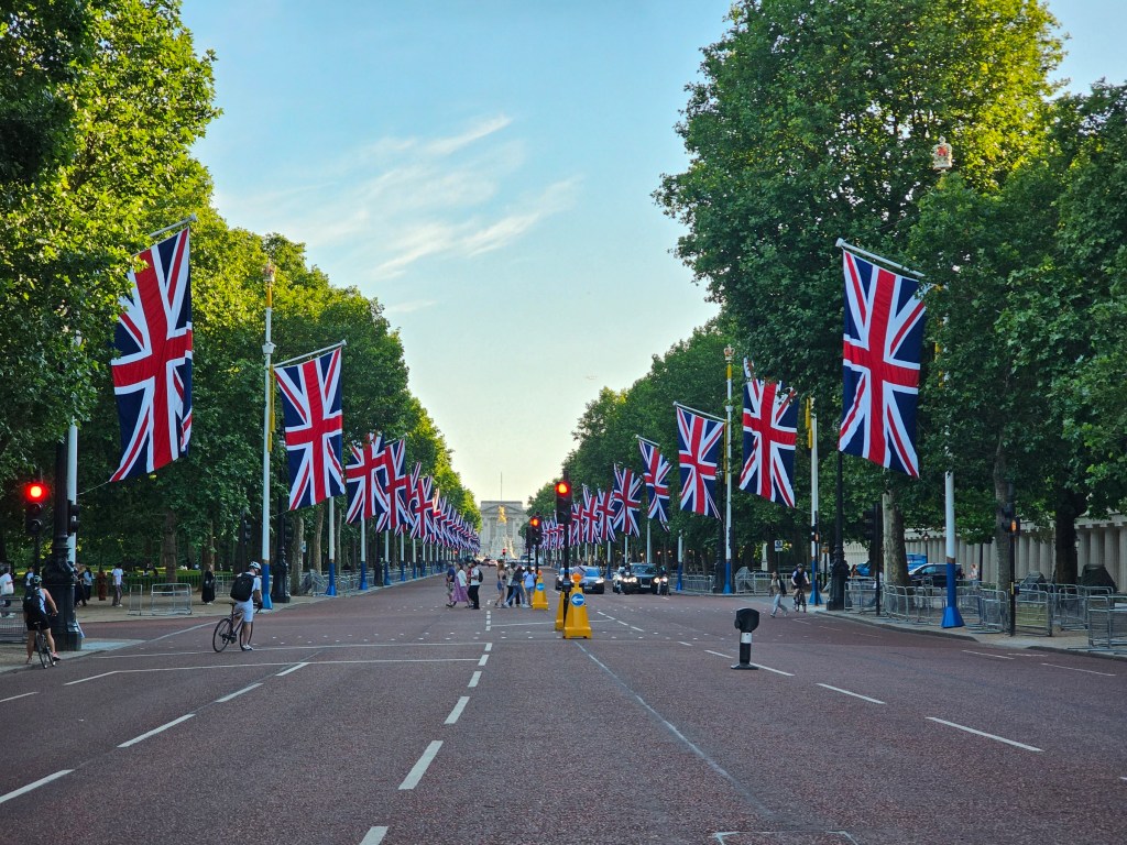 Pall Mall - a wide road leading to Buckingham Palace in London, with dozens of large Union Jack flags lining the street on both sides