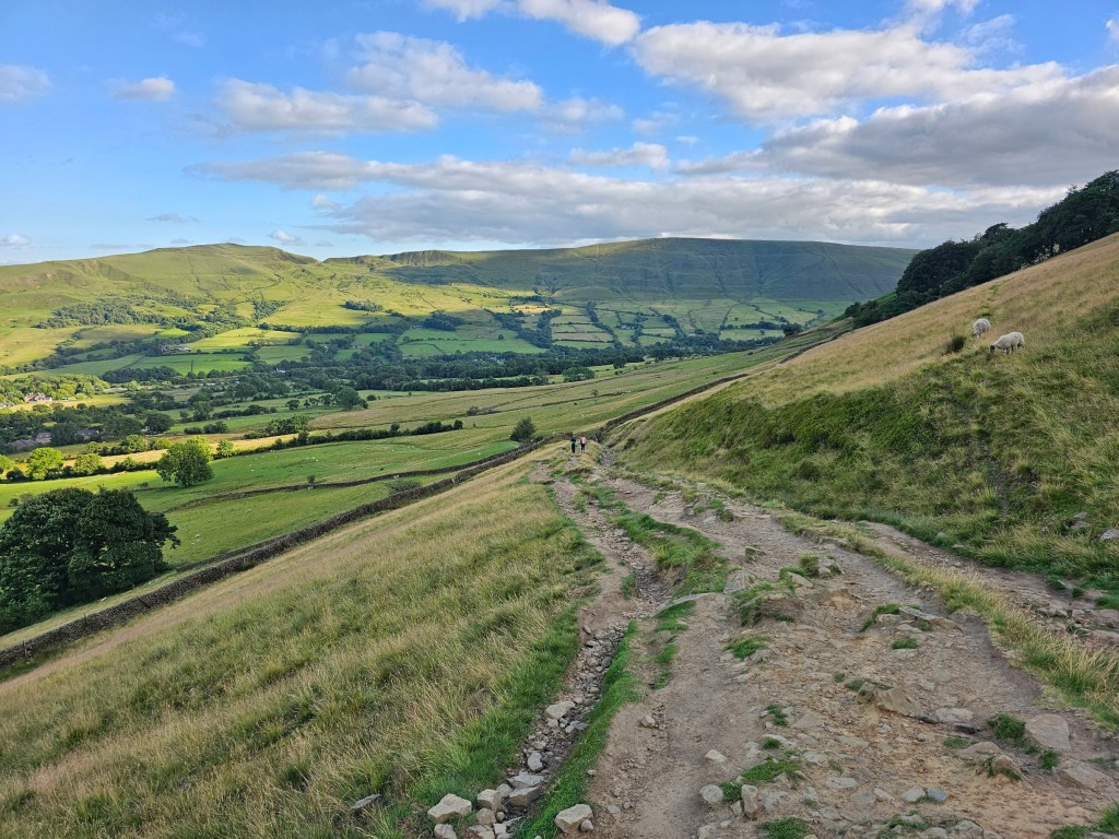 A wide countryside path through the hills in Peak District