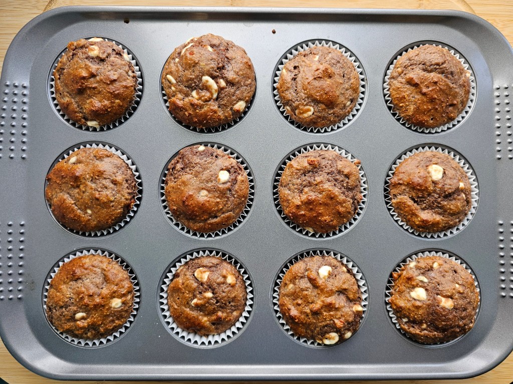 A muffin tray with 12 baked protein muffins