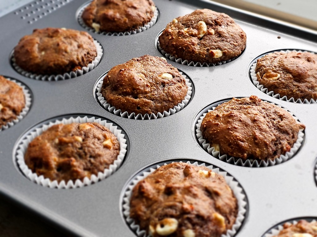 A close up view of a muffin tray with 12 baked protein muffins