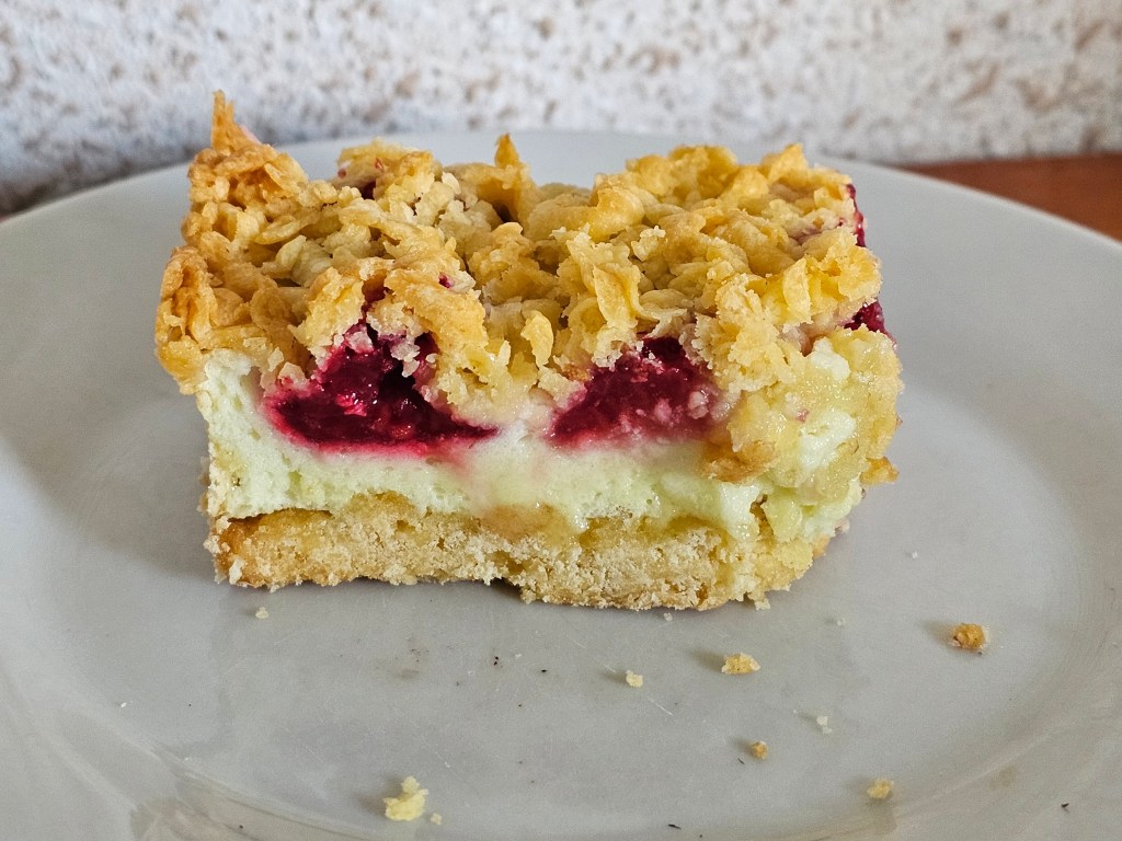 A slice of shortbread cake with a meringue layer and berries, on a plate