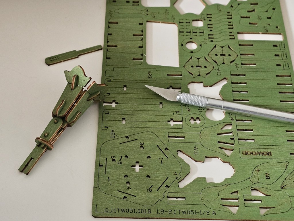 Cutting out green wooden pieces for a flower stem