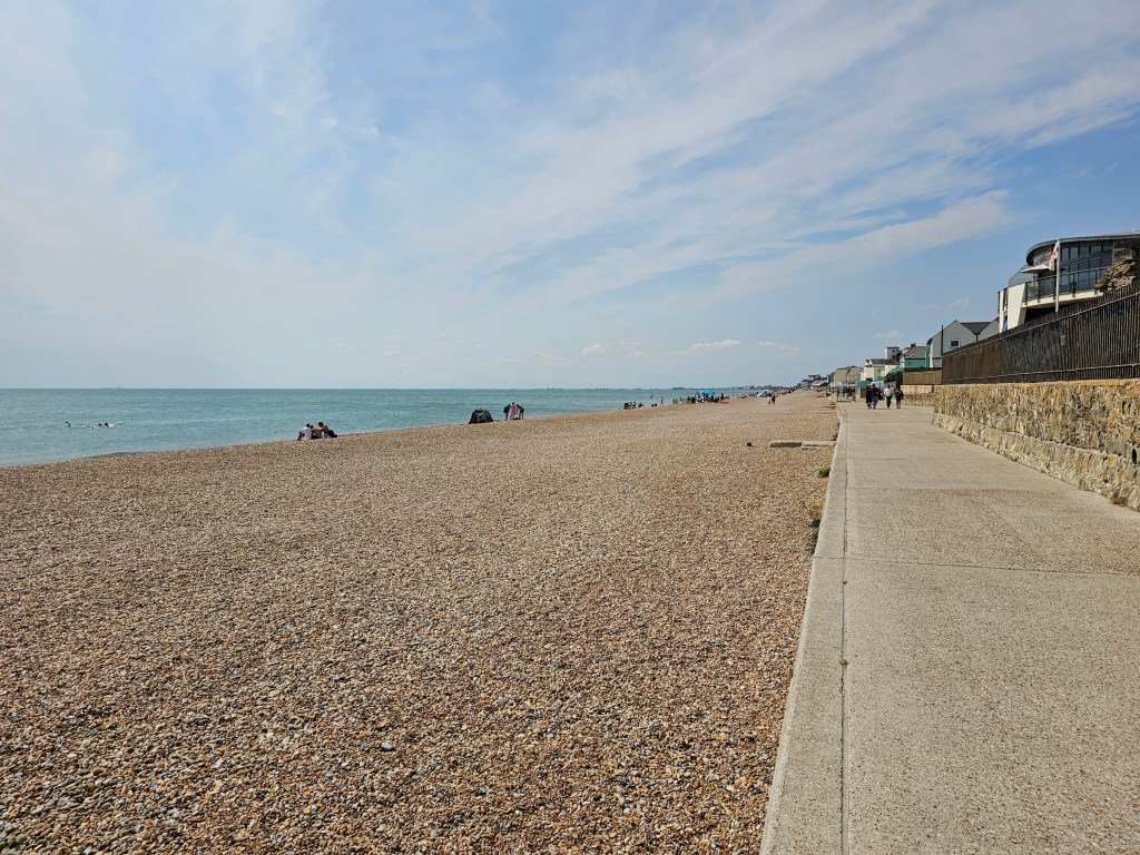 The sea, pebble beach, and a concrete path on the way from Folkestone to Hythe