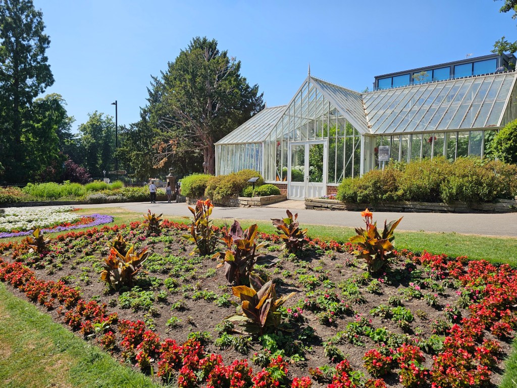 A glasshouse and a flower bed in a small park in Richmond, London