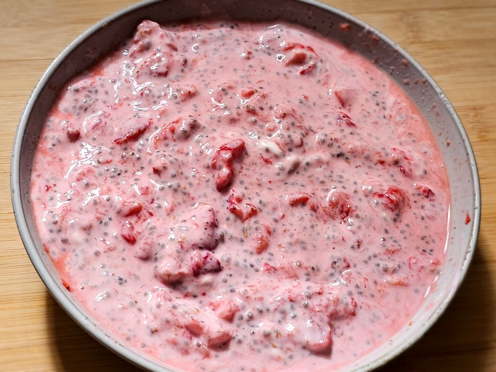 A plate with mashed strawberries mixed with natural yoghurt and chia seeds