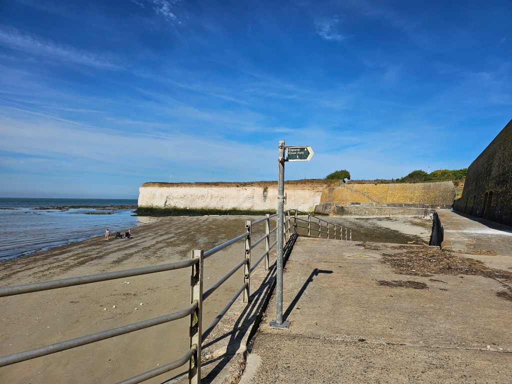 A signpost for English Coast Path on the way from Whitstable to Margate. White cliffs can be seen in the background