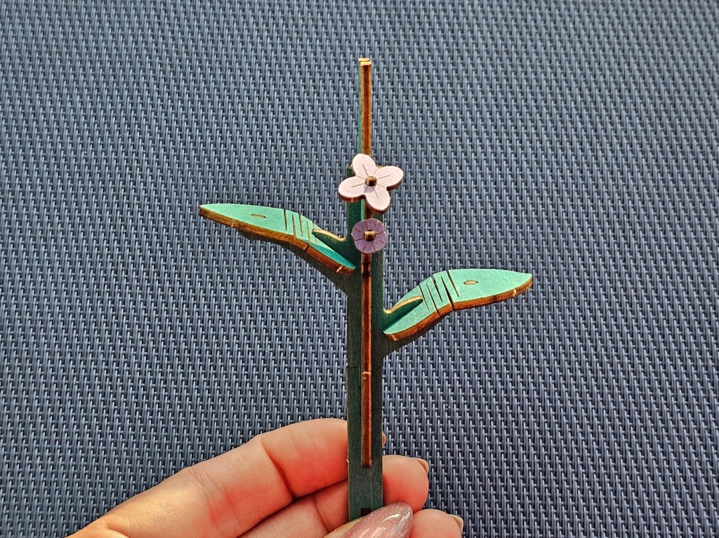 Wooden stem for a lilac flower, with two leaves and some tiny flowers