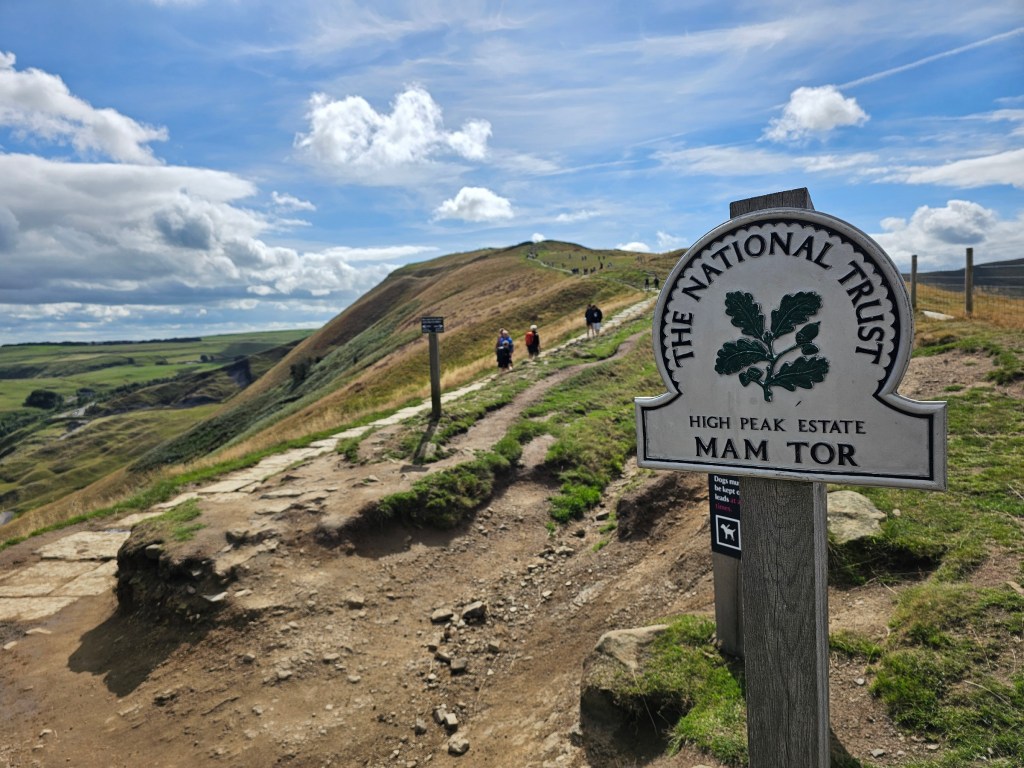 The peak of Mam Tor and National Trust signpost.