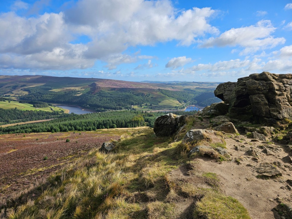 The top of Winn Hill in Peak District, with interesting rock formations. Reservoirs and other hills can be seen in the background.