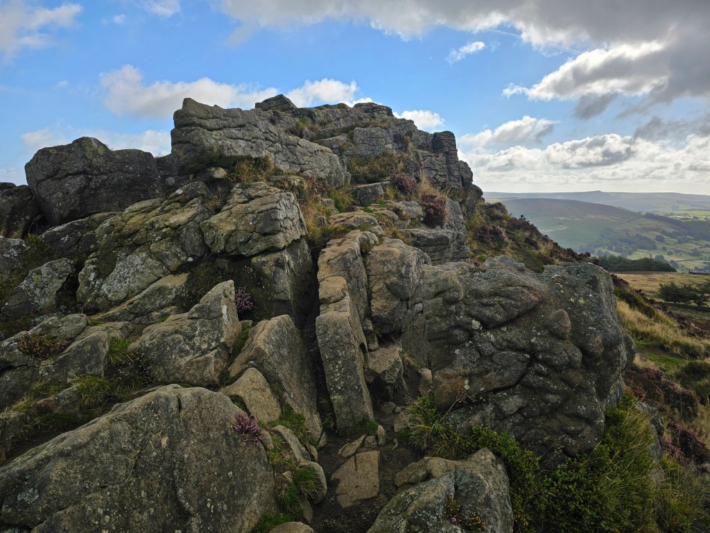 The top of Winn Hill in Peak District, with interesting rock formations. Other hills can be seen all around.
